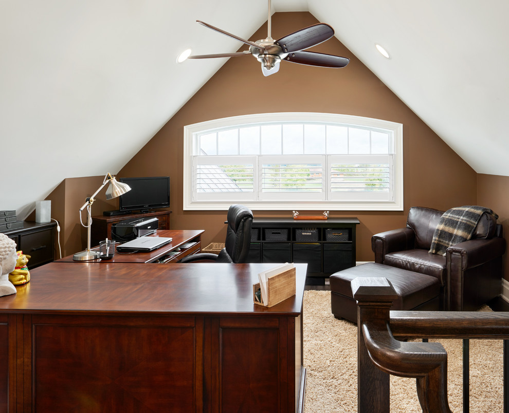 Imagen de despacho clásico de tamaño medio con paredes marrones, moqueta y escritorio independiente