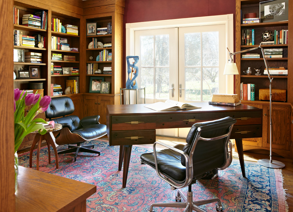 Example of a 1960s freestanding desk medium tone wood floor study room design in Boston with red walls
