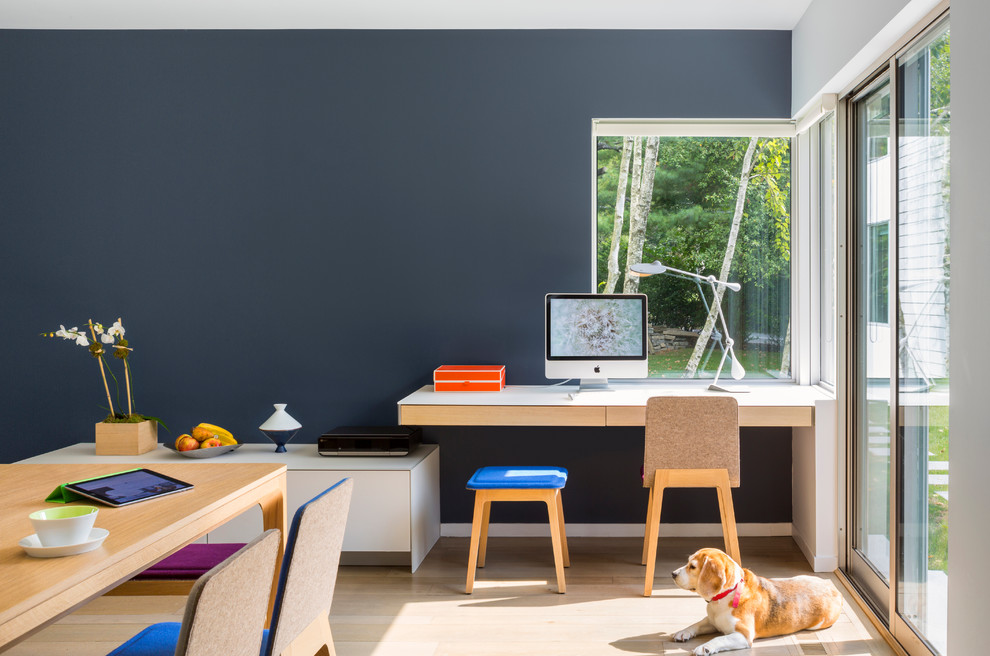 Réalisation d'un bureau design avec parquet clair, un bureau intégré, un mur gris et un sol marron.