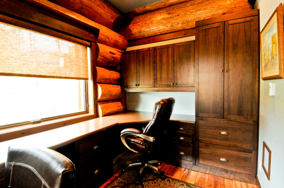 Diseño de despacho rural de tamaño medio con suelo de madera en tonos medios, escritorio empotrado y suelo marrón