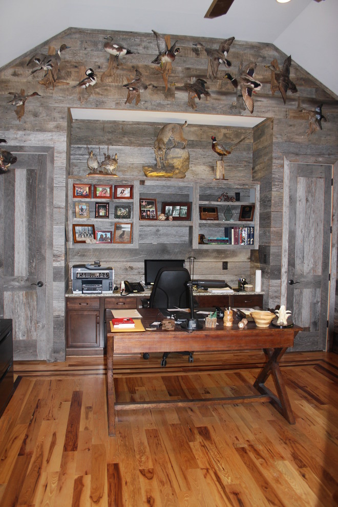 На фото: большой кабинет в стиле рустика с серыми стенами, светлым паркетным полом и отдельно стоящим рабочим столом без камина с