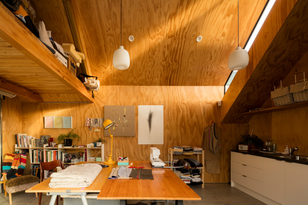 Cette image montre un bureau atelier minimaliste de taille moyenne avec sol en béton ciré et un bureau indépendant.