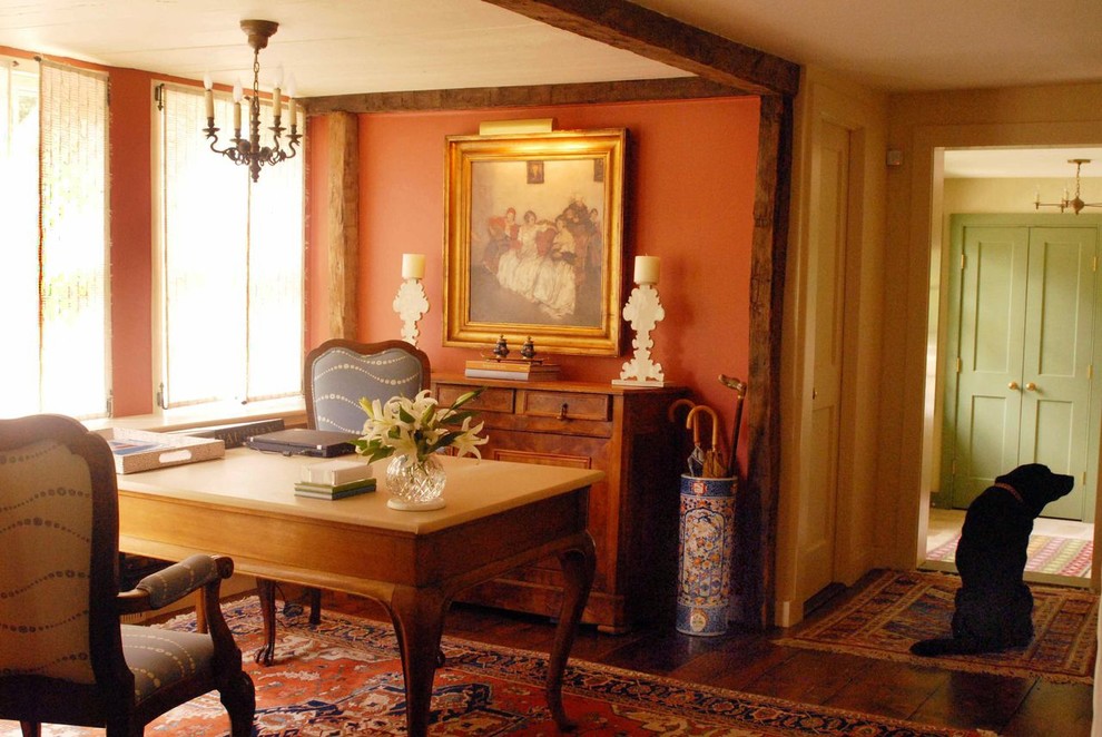 Immagine di uno studio tradizionale di medie dimensioni con pareti arancioni, parquet scuro e scrivania autoportante