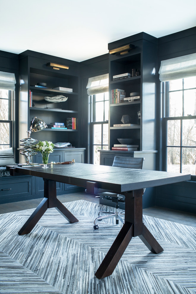 Geräumiges Klassisches Lesezimmer ohne Kamin mit blauer Wandfarbe, dunklem Holzboden und freistehendem Schreibtisch in New York