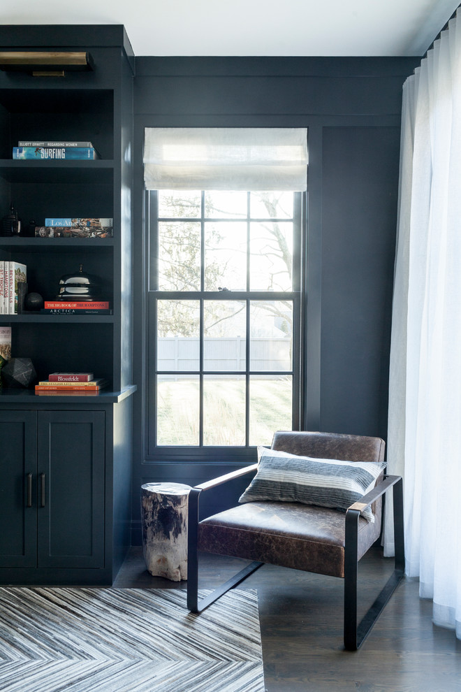 Пример оригинального дизайна: огромный домашняя библиотека в стиле неоклассика (современная классика) с синими стенами, темным паркетным полом и отдельно стоящим рабочим столом без камина