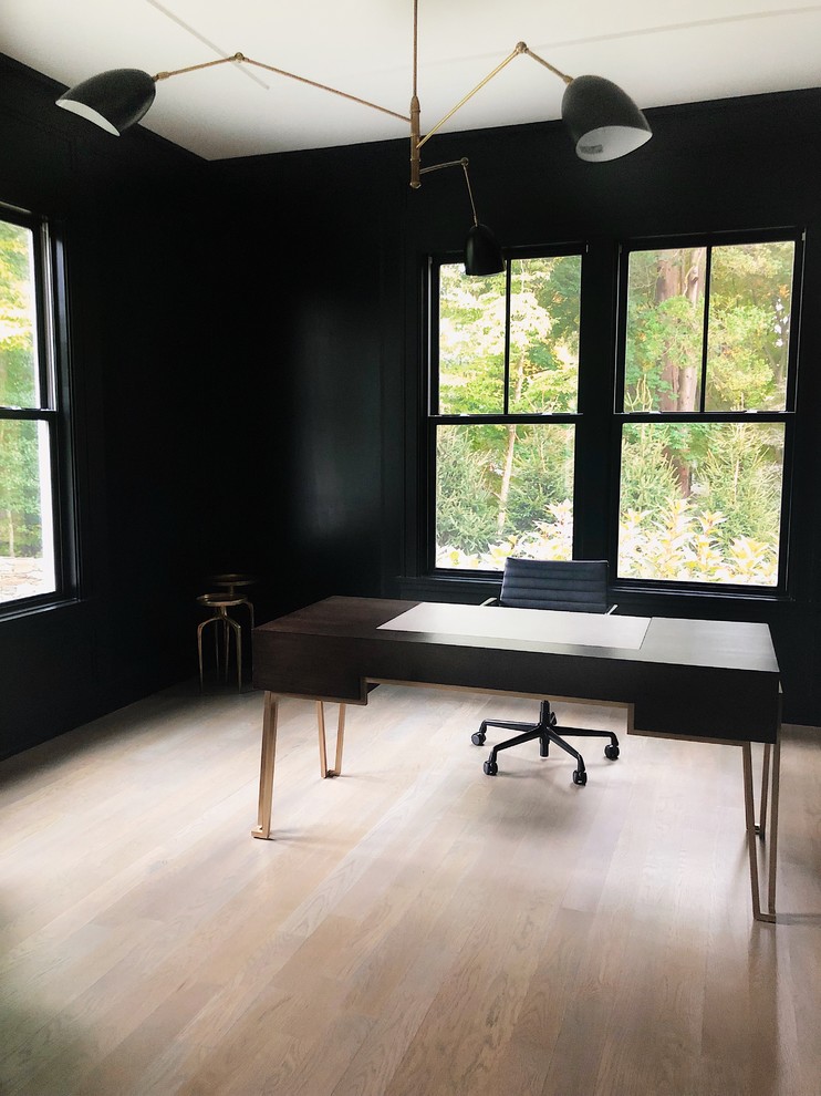 На фото: рабочее место среднего размера в современном стиле с черными стенами, паркетным полом среднего тона, отдельно стоящим рабочим столом и серым полом