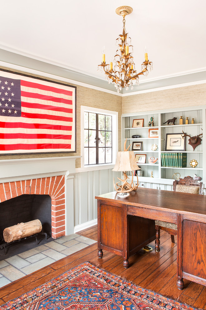 Home office - farmhouse freestanding desk dark wood floor and brown floor home office idea in Los Angeles with beige walls, a standard fireplace and a brick fireplace