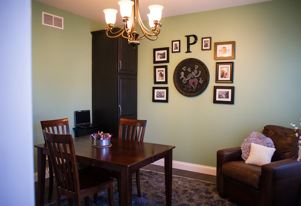Klassisches Arbeitszimmer ohne Kamin mit grüner Wandfarbe, dunklem Holzboden und freistehendem Schreibtisch in Sonstige
