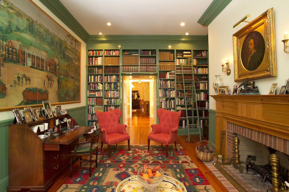 Großes Klassisches Lesezimmer mit grüner Wandfarbe, braunem Holzboden, Kamin, Kaminumrandung aus Holz und freistehendem Schreibtisch in Atlanta