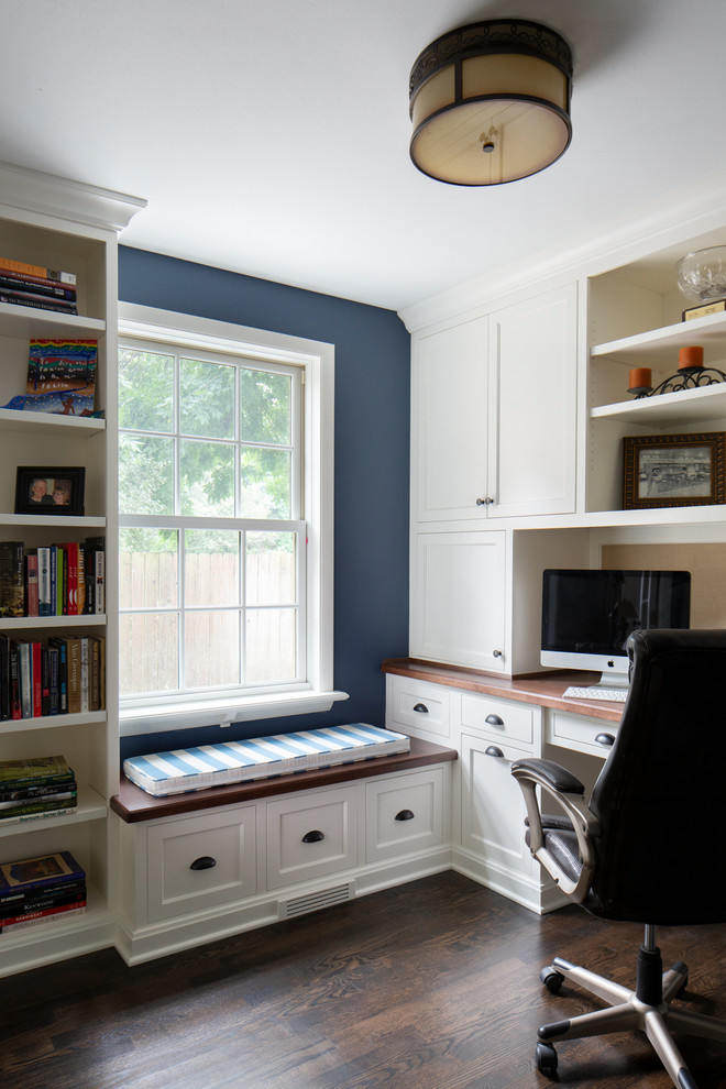 Esempio di un piccolo studio chic con libreria, pareti blu, parquet scuro, scrivania incassata e pavimento marrone