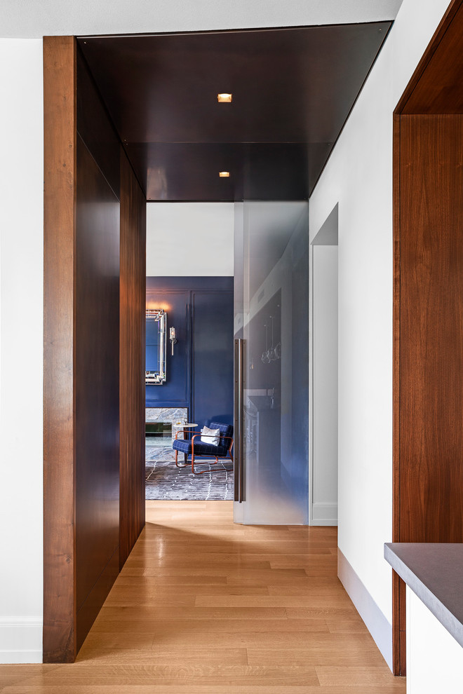 Источник вдохновения для домашнего уюта: рабочее место в стиле модернизм с синими стенами, двусторонним камином, фасадом камина из камня и встроенным рабочим столом