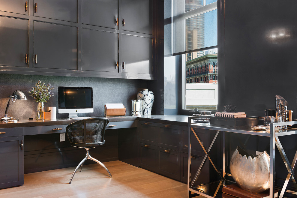 Large contemporary study in New York with blue walls, a built-in desk, medium hardwood flooring and brown floors.