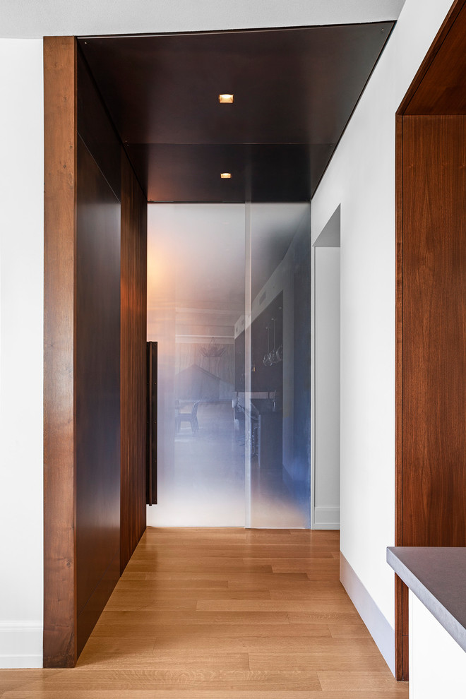 Imagen de despacho minimalista con paredes azules, chimenea de doble cara, marco de chimenea de piedra y escritorio empotrado