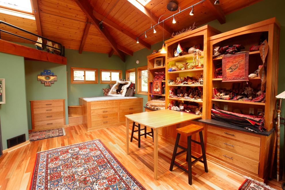 Rustikales Nähzimmer mit grüner Wandfarbe, braunem Holzboden und Einbau-Schreibtisch in Sonstige