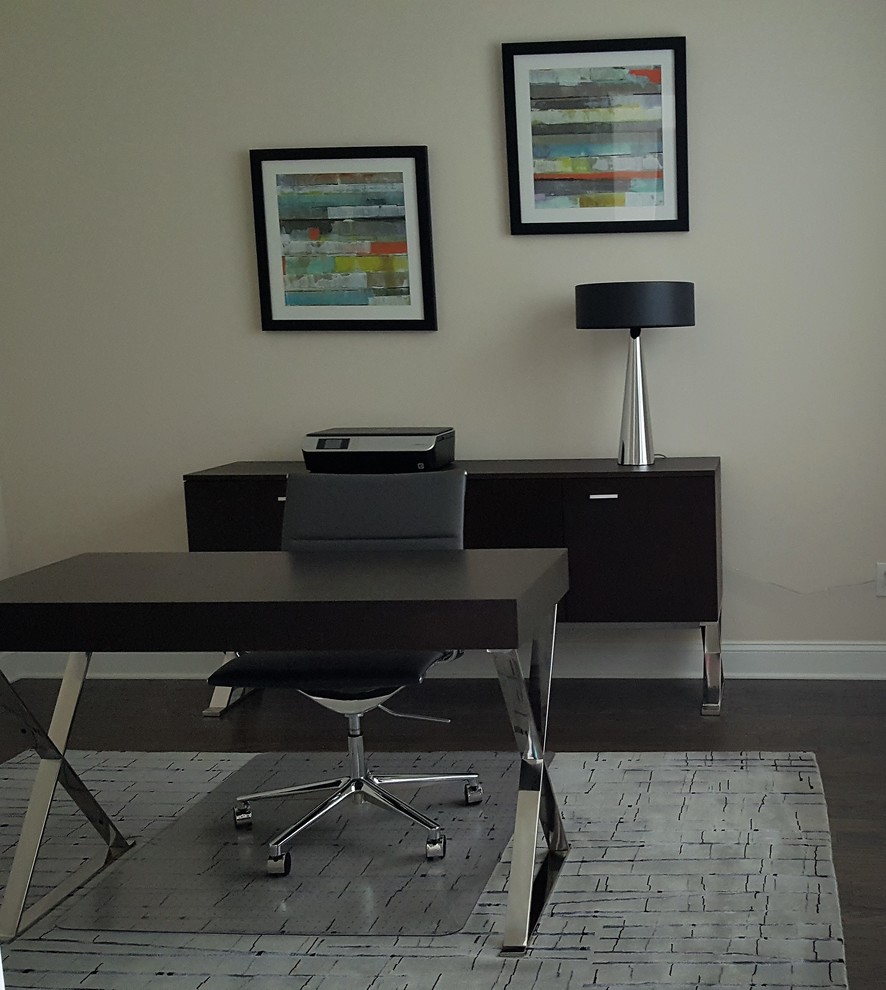 This is an example of a small contemporary home office in Raleigh with grey walls, dark hardwood flooring and a freestanding desk.