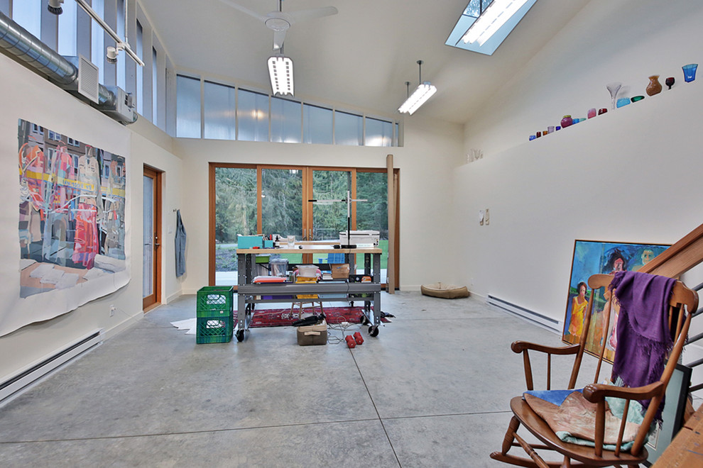 На фото: домашняя мастерская в стиле лофт с белыми стенами, бетонным полом и серым полом