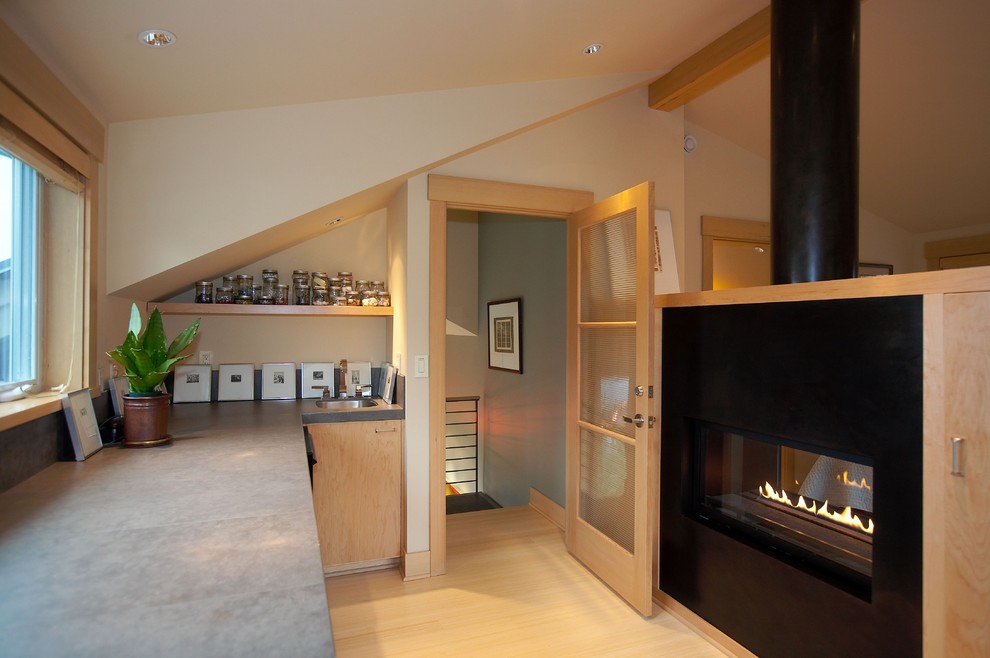 シアトルにあるコンテンポラリースタイルのおしゃれなホームオフィス・書斎 (ベージュの壁、淡色無垢フローリング、横長型暖炉) の写真