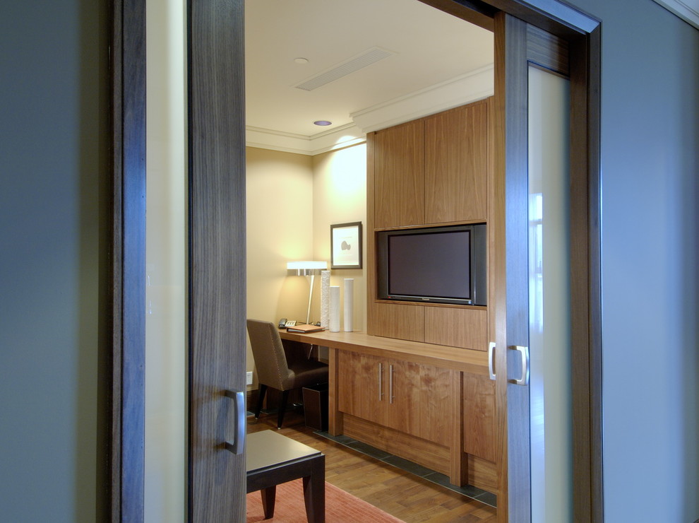 Exemple d'un bureau tendance avec un mur beige, un sol en bois brun et un bureau intégré.