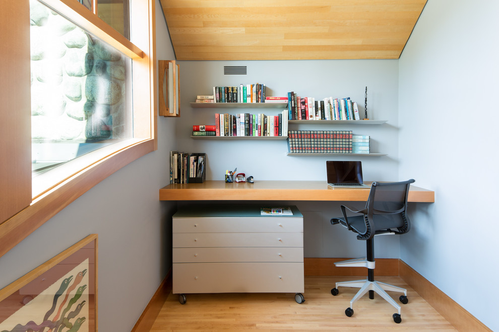 Idéer för att renovera ett litet funkis hemmabibliotek, med grå väggar, ljust trägolv, ett inbyggt skrivbord och brunt golv