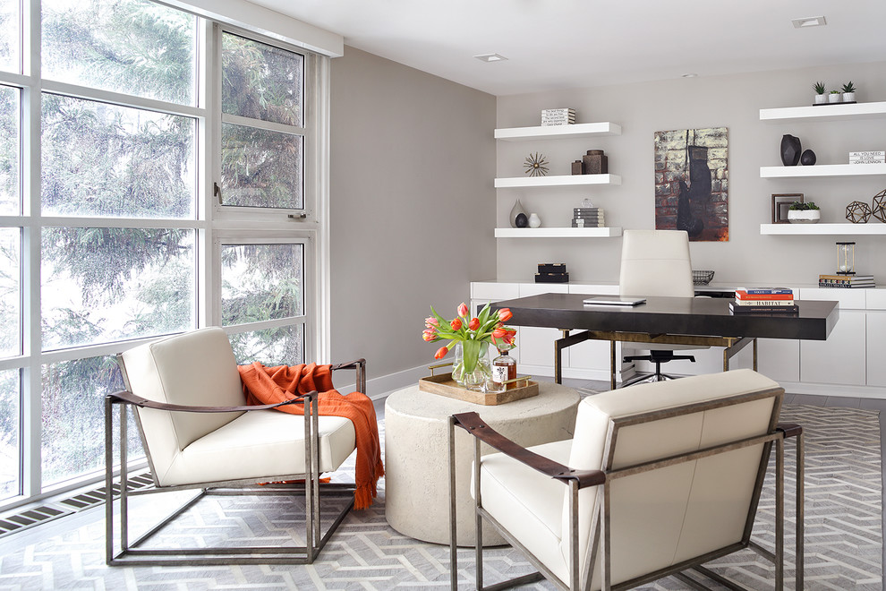 Modernes Arbeitszimmer mit grauer Wandfarbe, Einbau-Schreibtisch und grauem Boden in New York