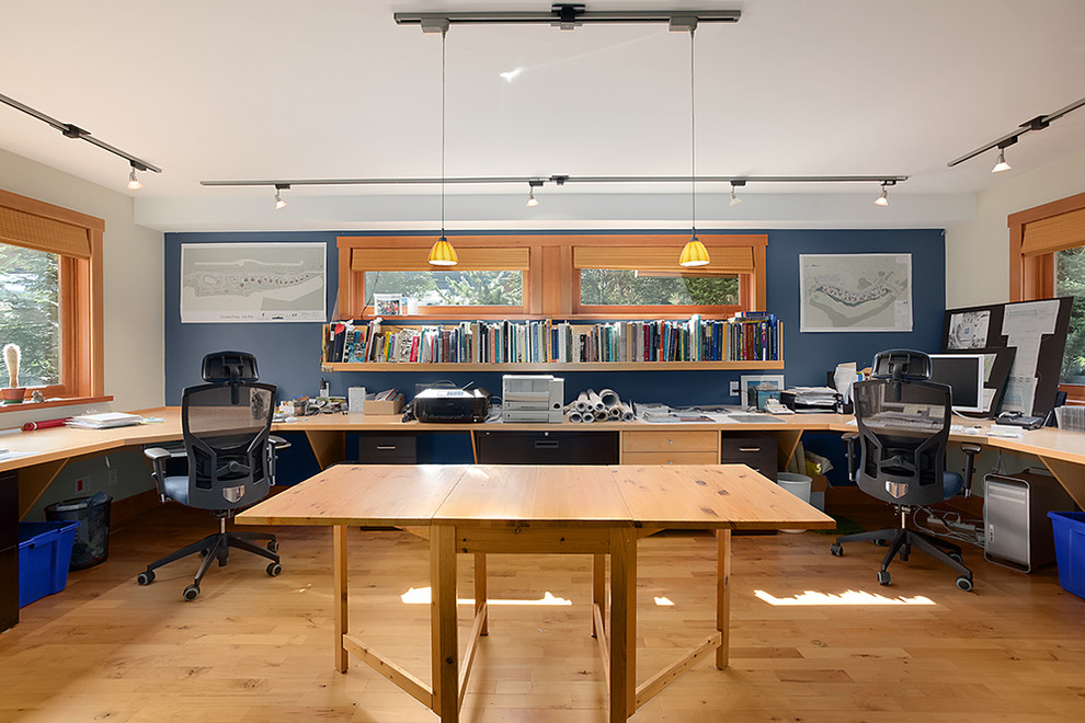 Idéer för ett stort modernt hemmastudio, med blå väggar, mellanmörkt trägolv och ett inbyggt skrivbord