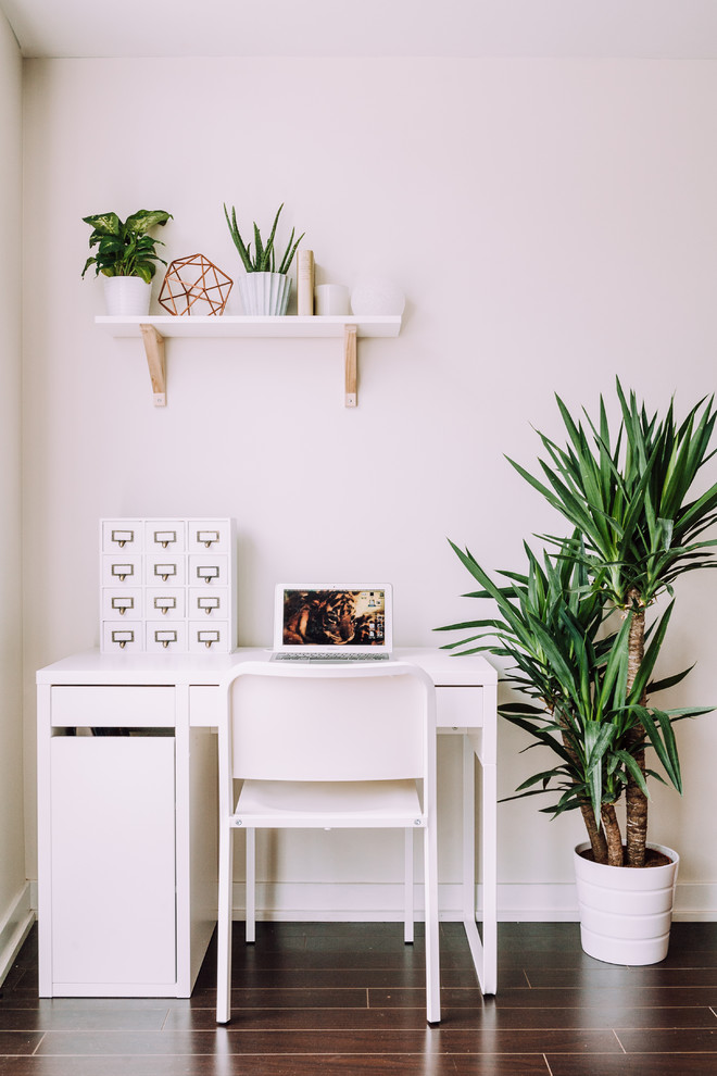 Imagen de despacho contemporáneo pequeño con paredes blancas, suelo de madera oscura y escritorio independiente