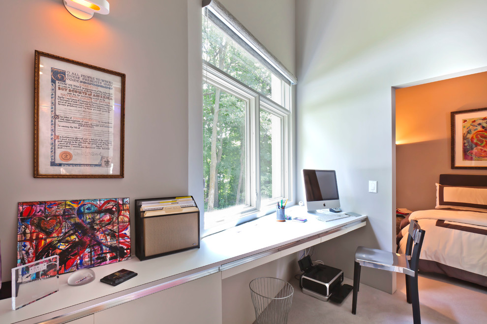 Idée de décoration pour un petit bureau design avec moquette et un bureau intégré.