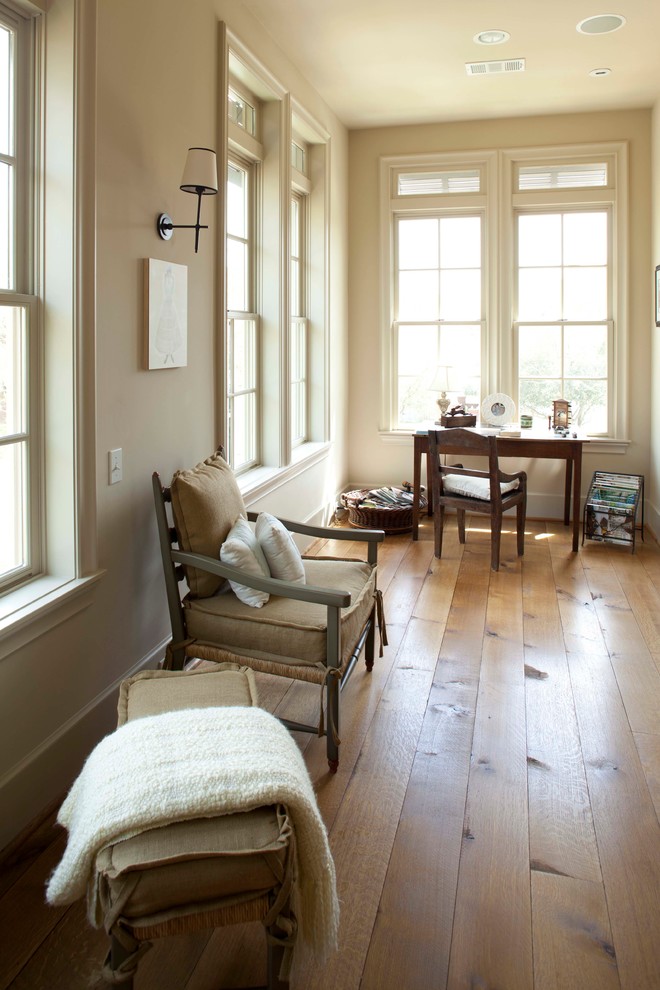 Geräumiges Rustikales Arbeitszimmer mit beiger Wandfarbe, braunem Boden, braunem Holzboden und freistehendem Schreibtisch in Houston