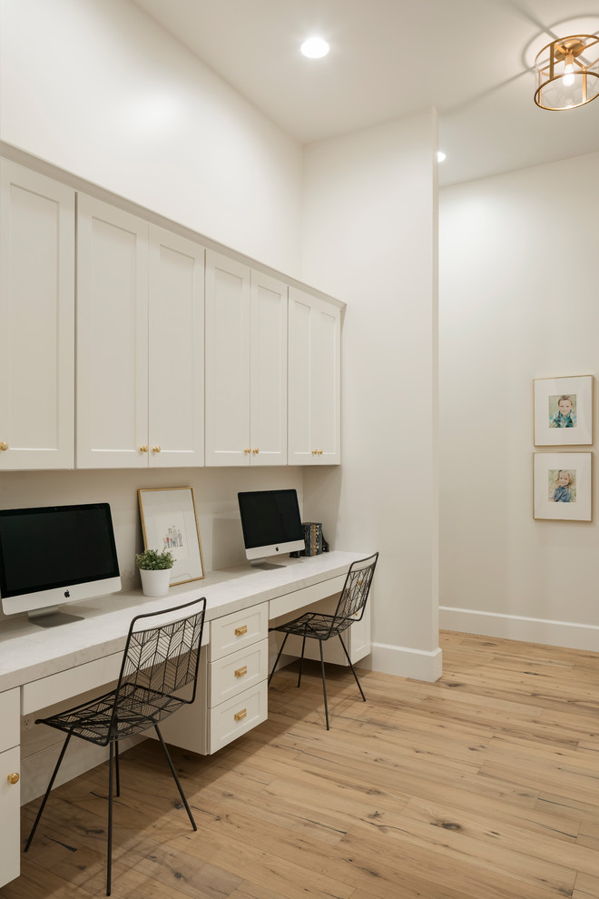 Large transitional built-in desk light wood floor and beige floor study room photo in Phoenix with white walls