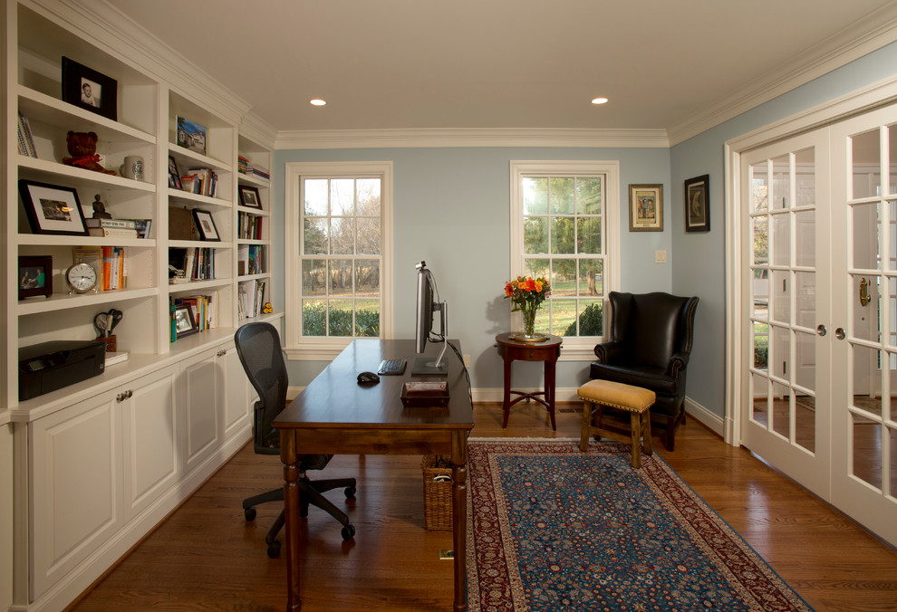 Foto på ett mellanstort vintage hemmabibliotek, med blå väggar, klinkergolv i porslin, ett fristående skrivbord och brunt golv