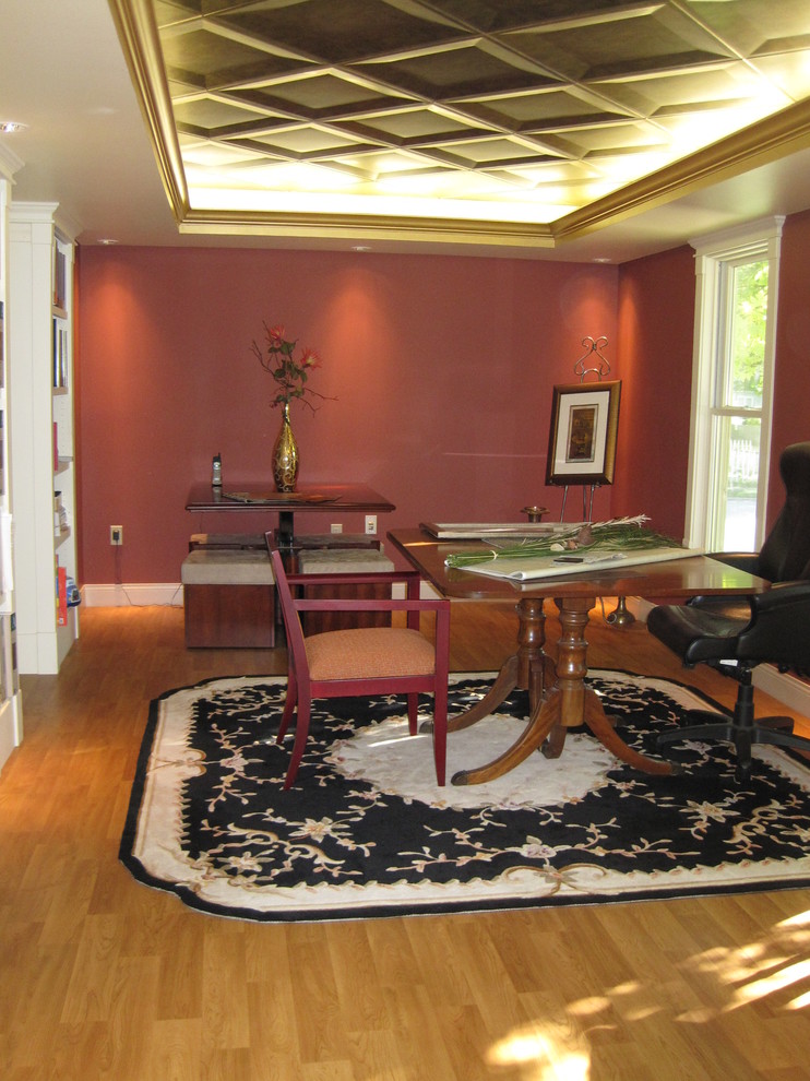 Inspiration för mellanstora klassiska arbetsrum, med mellanmörkt trägolv, ett bibliotek, röda väggar och ett fristående skrivbord