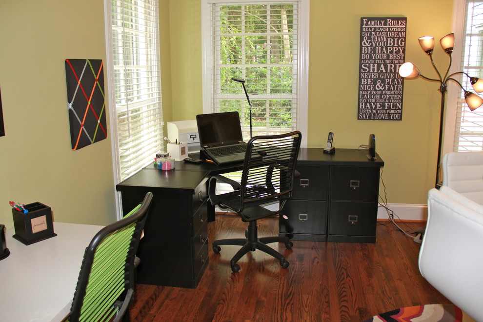 Cette image montre un bureau bohème de taille moyenne avec un mur vert, un sol en bois brun et un bureau indépendant.