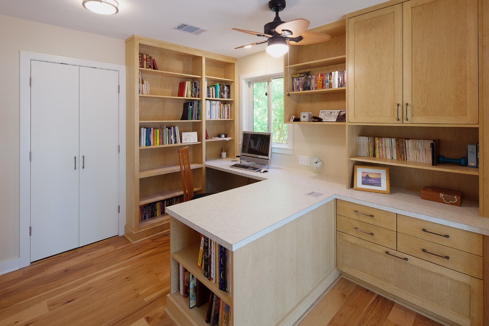 Photo of a classic home office in Austin with beige walls, light hardwood flooring and brown floors.