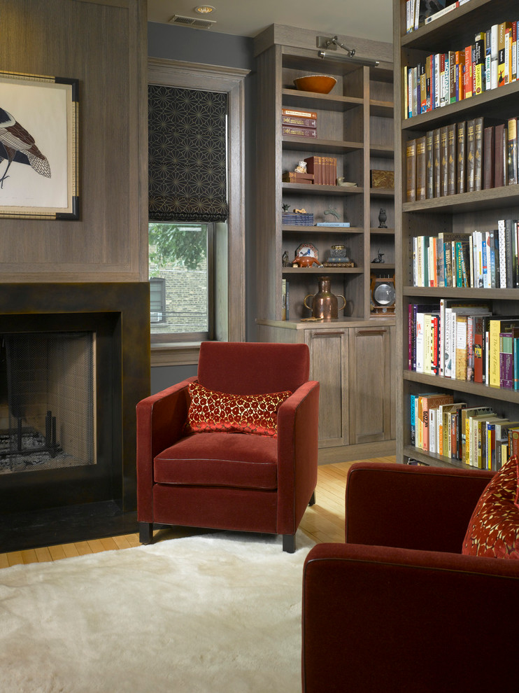 Mid-sized elegant light wood floor study room photo in Chicago with gray walls, a standard fireplace and a metal fireplace