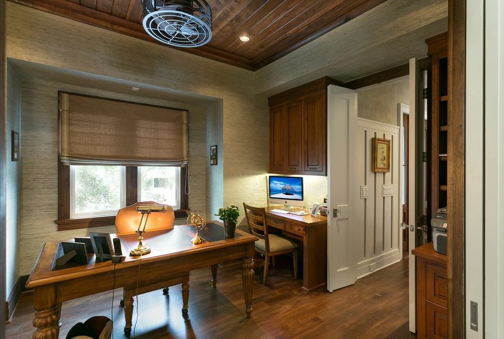 Diseño de despacho marinero con paredes beige, suelo de madera en tonos medios y escritorio independiente