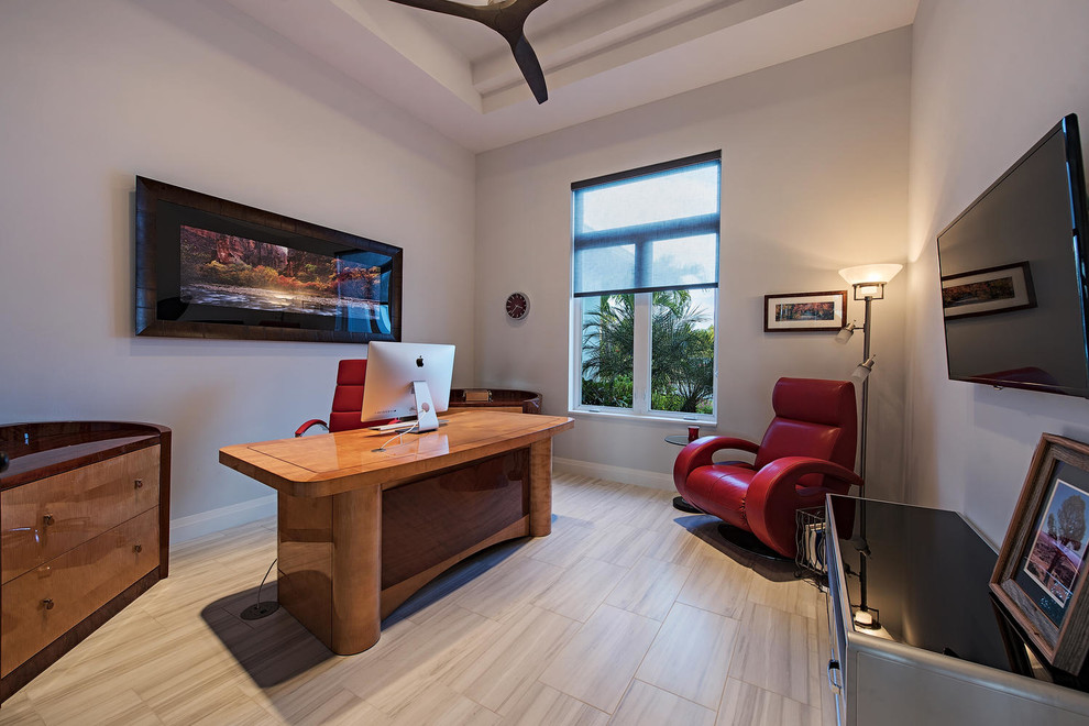 Diseño de despacho contemporáneo con paredes blancas, suelo de madera clara, escritorio independiente y suelo beige