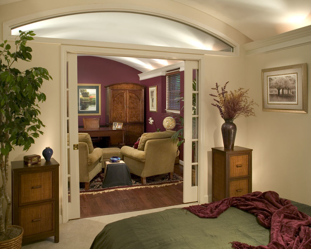 Mittelgroßes Klassisches Schlafzimmer ohne Kamin mit roter Wandfarbe und braunem Holzboden in Atlanta