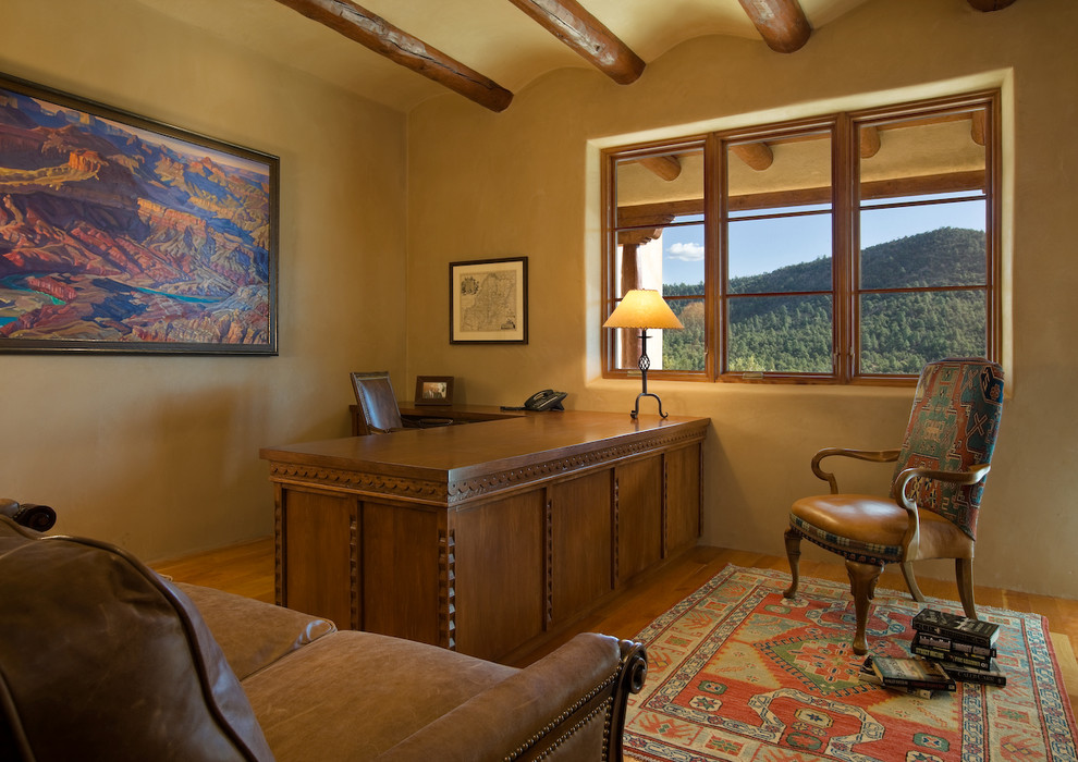 Diseño de despacho de estilo americano de tamaño medio con paredes beige, suelo de madera en tonos medios y escritorio empotrado