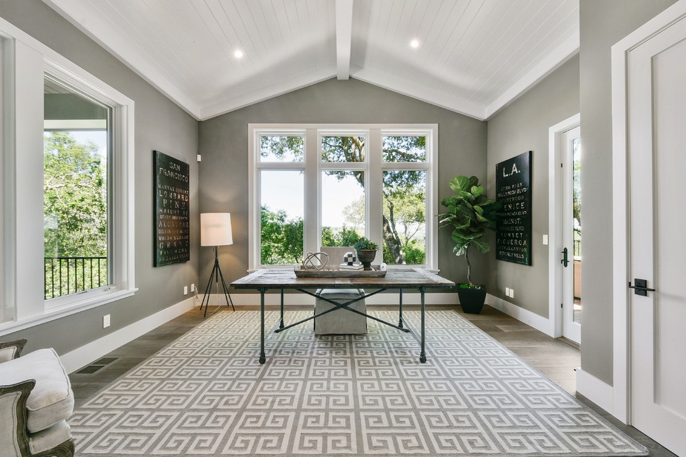 Klassisches Arbeitszimmer mit grauer Wandfarbe, braunem Holzboden, freistehendem Schreibtisch und grauem Boden in San Francisco