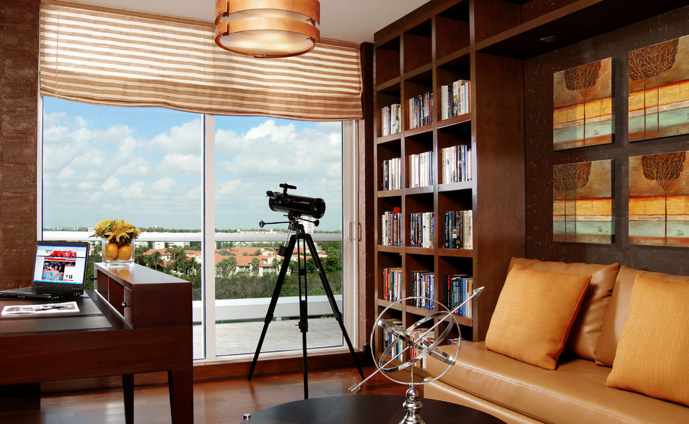マイアミにある高級な中くらいなコンテンポラリースタイルのおしゃれなホームオフィス・書斎 (ライブラリー、茶色い壁、濃色無垢フローリング、暖炉なし、自立型机) の写真