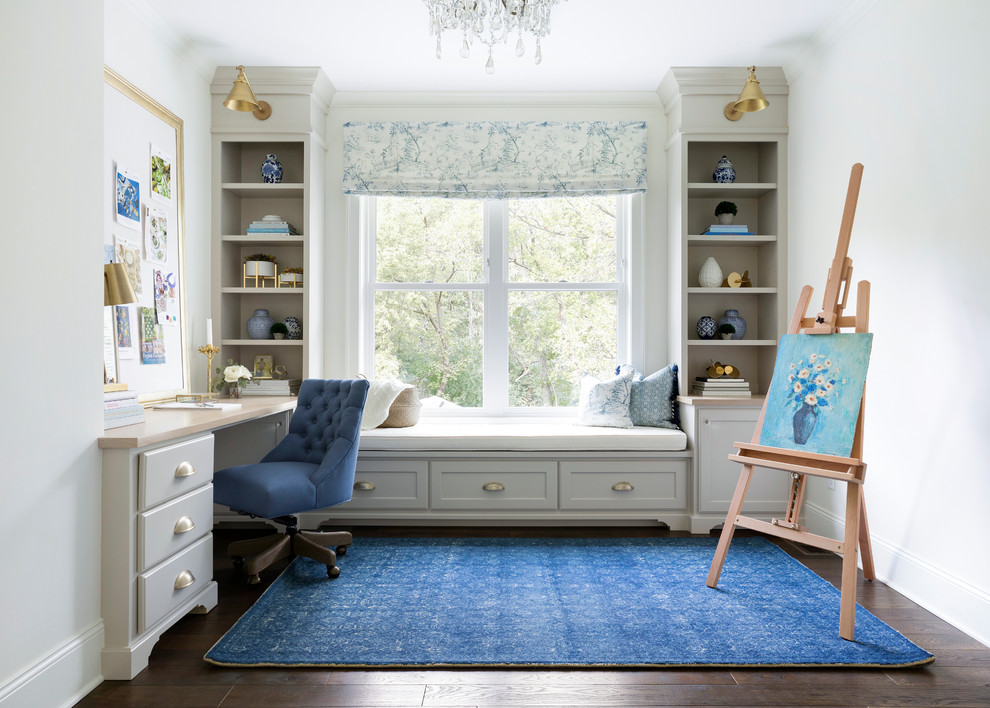 Inspiration for a traditional home studio in Minneapolis with white walls, dark hardwood flooring and a built-in desk.