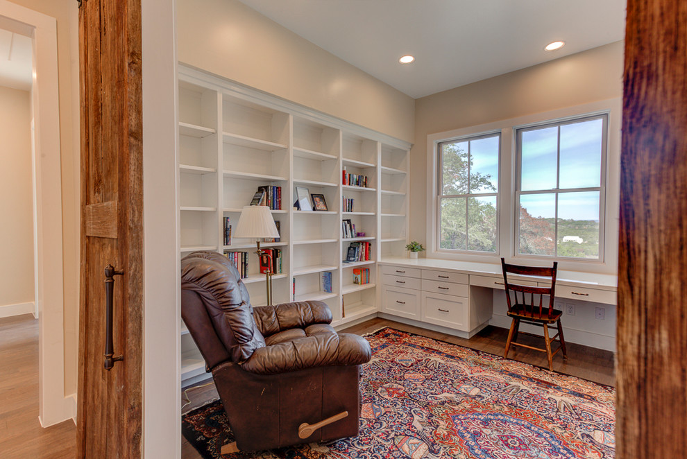 Inspiration för mellanstora lantliga arbetsrum, med ett bibliotek, beige väggar, mellanmörkt trägolv, ett inbyggt skrivbord och brunt golv