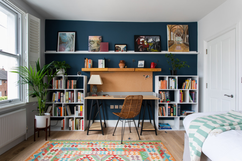 Mittelgroßes Modernes Arbeitszimmer mit Arbeitsplatz, hellem Holzboden, freistehendem Schreibtisch, weißer Wandfarbe und beigem Boden in London
