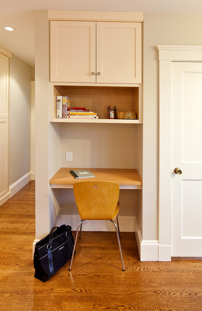 Diseño de despacho contemporáneo pequeño sin chimenea con paredes beige, suelo de madera en tonos medios, escritorio empotrado y suelo marrón
