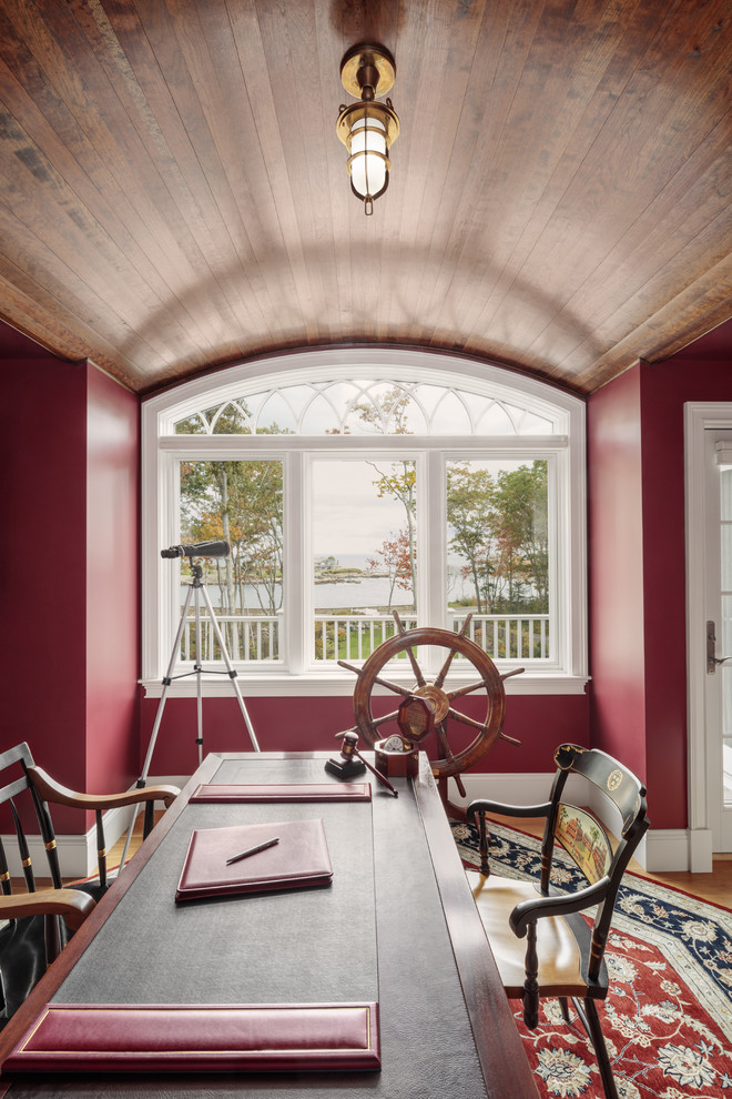 Inspiration för ett rustikt hemmabibliotek, med röda väggar, ett fristående skrivbord och ljust trägolv