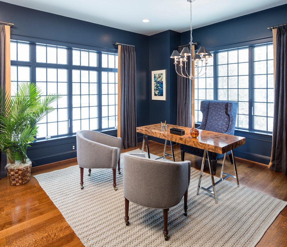 Diseño de despacho contemporáneo de tamaño medio sin chimenea con paredes azules, suelo de madera en tonos medios y escritorio independiente