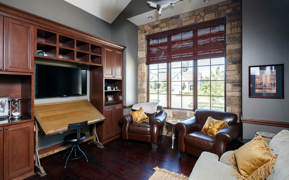 Diseño de despacho tradicional de tamaño medio con paredes grises, suelo de madera en tonos medios y escritorio independiente