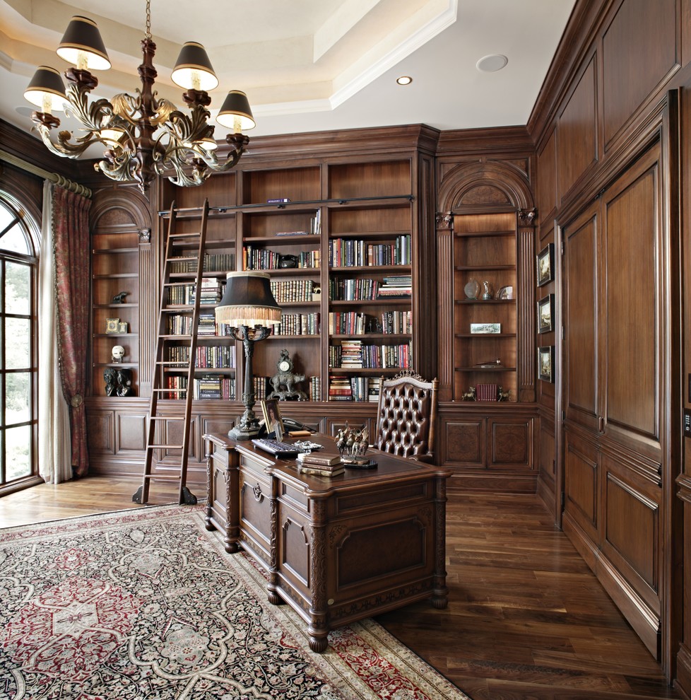Klassisk inredning av ett stort arbetsrum, med ett bibliotek och ett fristående skrivbord