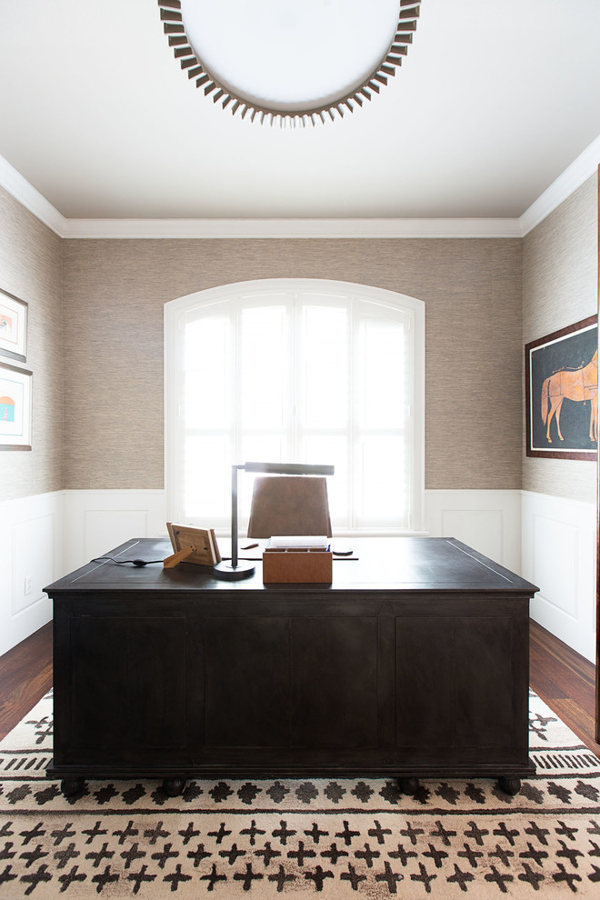 Mittelgroßes Klassisches Arbeitszimmer mit brauner Wandfarbe, dunklem Holzboden, Kamin, Kaminumrandung aus Holz und freistehendem Schreibtisch in Orlando