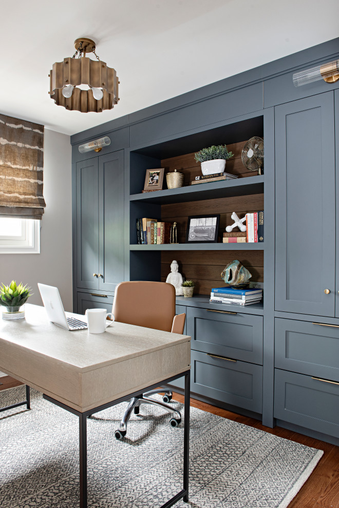 Photo of a medium sized traditional study in Toronto with grey walls, medium hardwood flooring, a freestanding desk and red floors.